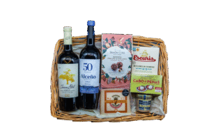 Cesta aperitivo gourmet con vinos, conservas gallegas, paté de ciervo, queso viejo y bombones.