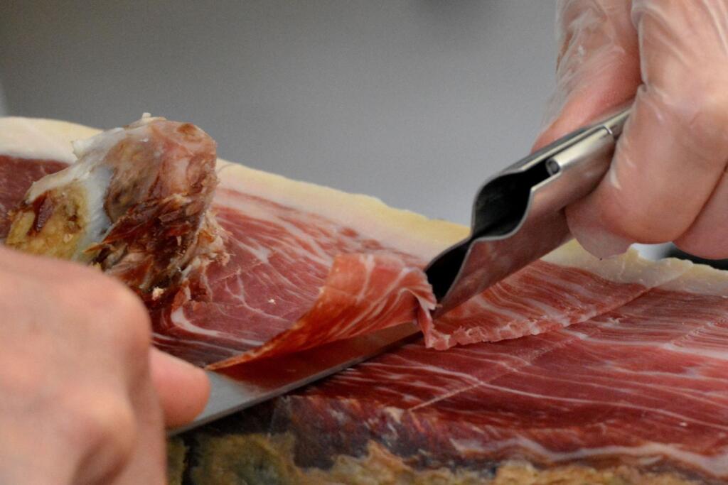 Jamón serrano vs jamón ibérico: corte a mano con cuchillo jamonero de una loncha fina