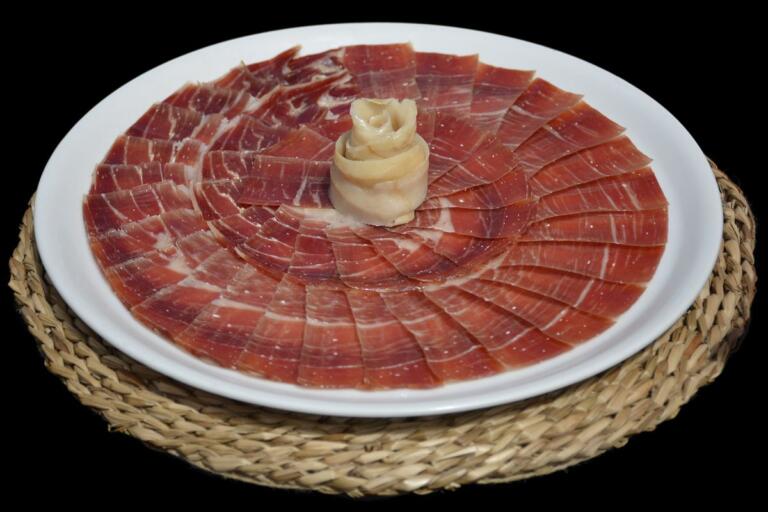 Jamón ibérico loncheado mostrando su veteado de grasa infiltrada y textura jugosa