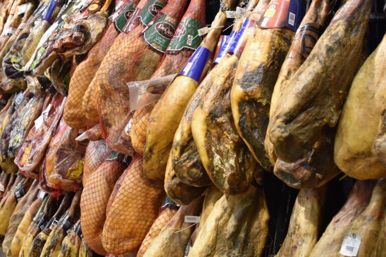 Jamones ibéricos y serranos colgados en curación en secadero tradicional español