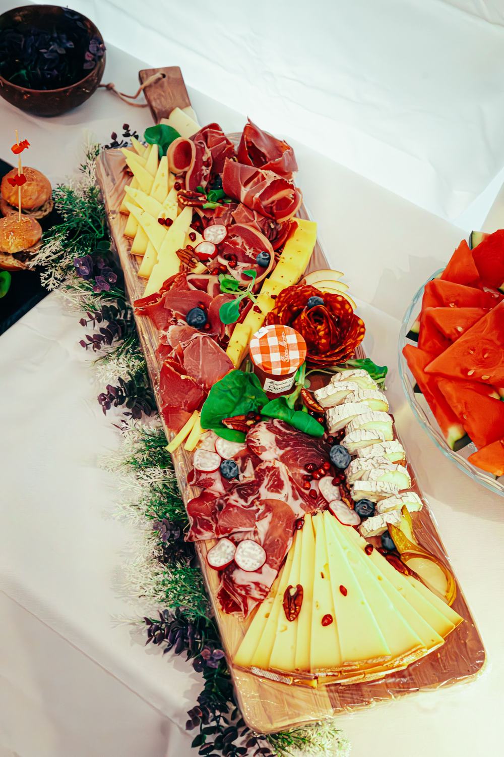 Tabla de jamón, quesos y embutidos con arándanos, granada y mermelada de naranja para una mesa gourmet de Navidad